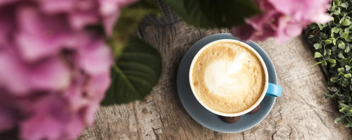 top-view-pink-flower-tasty-coffee-with-frothy-foam-wooden-surface